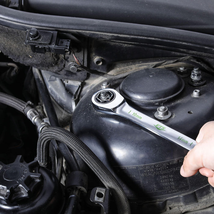 Ratcheting wrench with quick-change conversion head adjusting a bolt inside an engine
