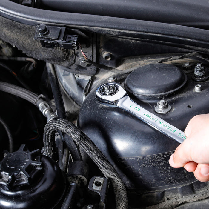 Ratcheting wrench with quick-change conversion head adjusting a bolt inside an engine
