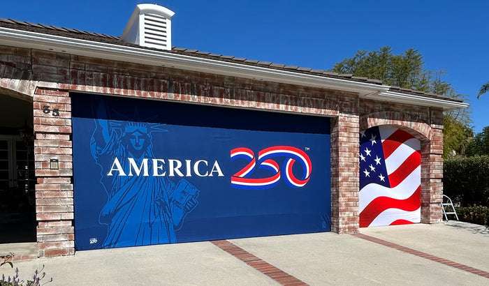 Garage door with 'America 250' design and American flag on a house exterior.