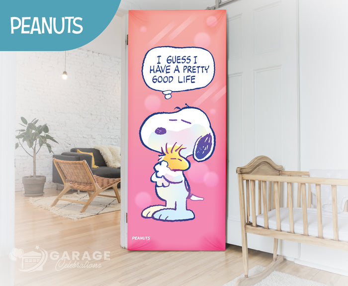 Garage door with Snoopy design and 'Peanuts' branding in a room with a crib and plant.