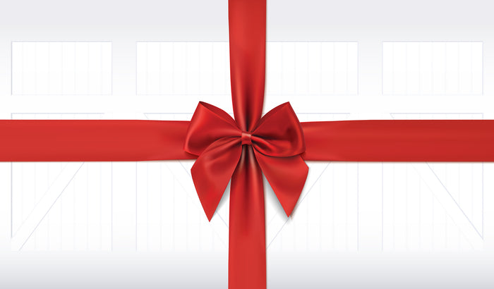 Large red ribbon with a bow on a white farmhouse garage door background.