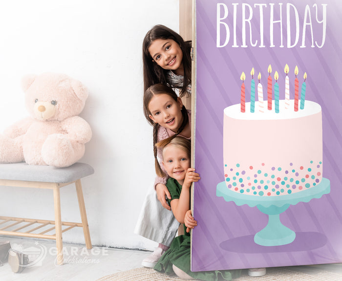 Three children peeking from behind a bedroom door with a birthday cake cover.