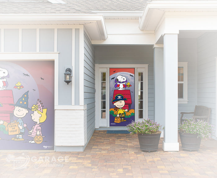 Snoopy and Charlie Brown characters in Halloween costumes on a roof with pumpkins and bats on a house exterior.